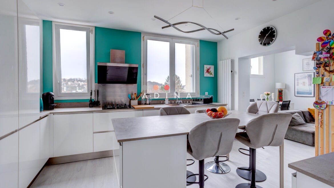 Cuisine moderne avec îlot central et fenêtres.