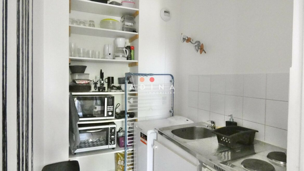 Cuisine compacte avec étagères et électroménagers.