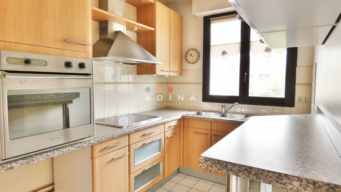 Cuisine moderne avec meubles en bois et électroménagers intégrés.