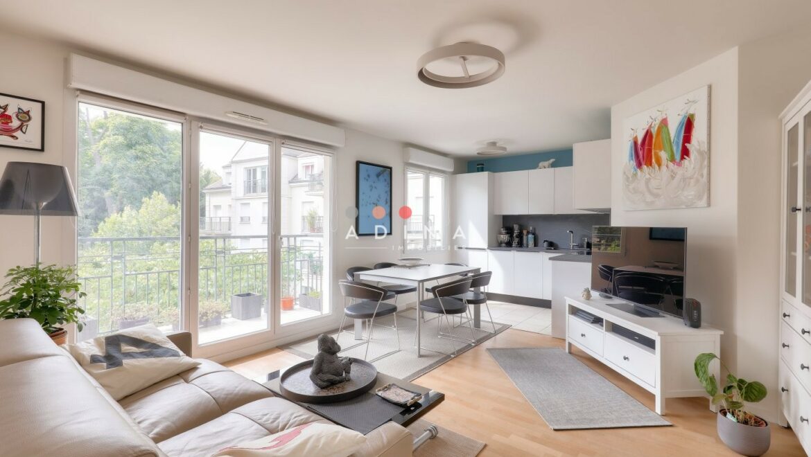 Salon moderne avec cuisine ouverte et balcon.