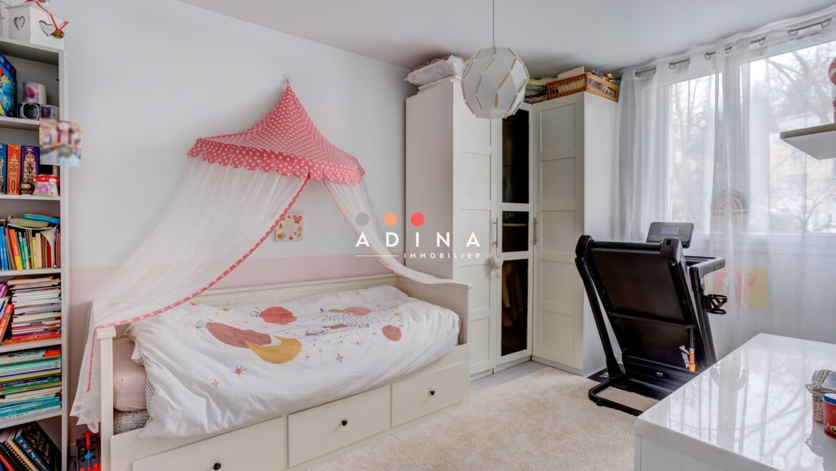 Chambre d'enfant avec lit, armoire et tapis.