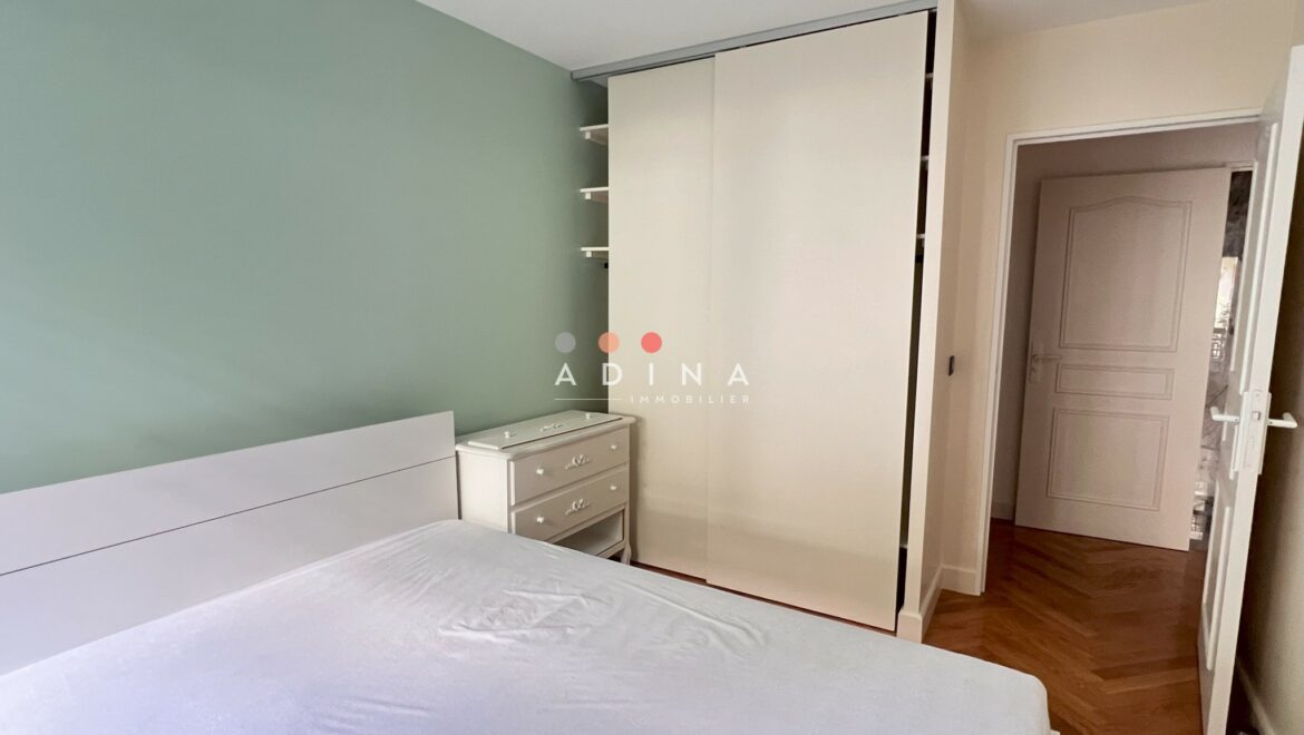Chambre à coucher avec placard blanc et mur vert.