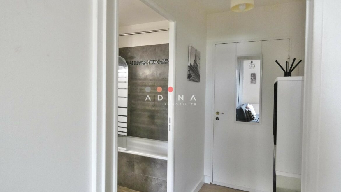 Couloir avec porte menant à une salle de bain.