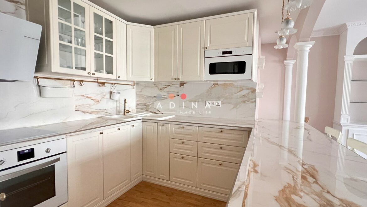 Cuisine moderne avec marbre et mobilier blanc.