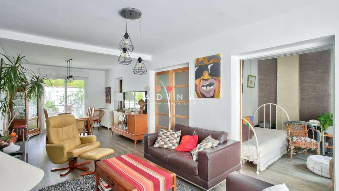 Salon moderne avec canapé en cuir et décoration colorée.