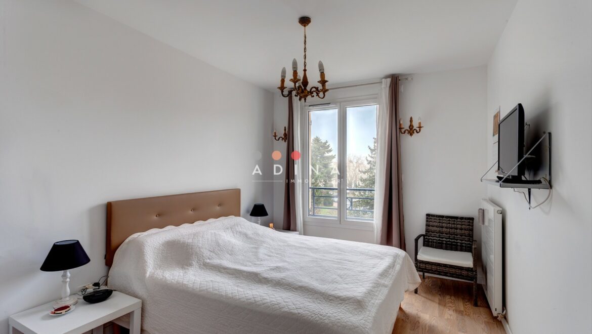 Chambre lumineuse avec lit double et fenêtre.