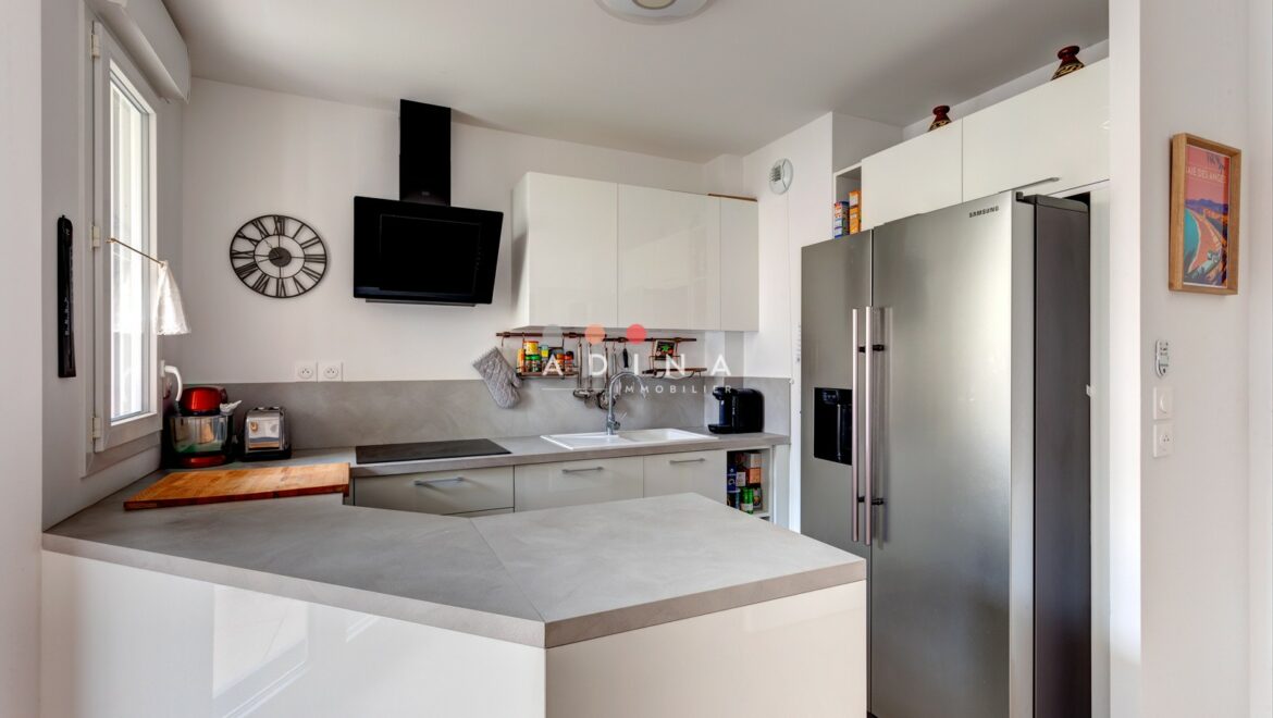 Cuisine moderne avec grand réfrigérateur en acier inoxydable.