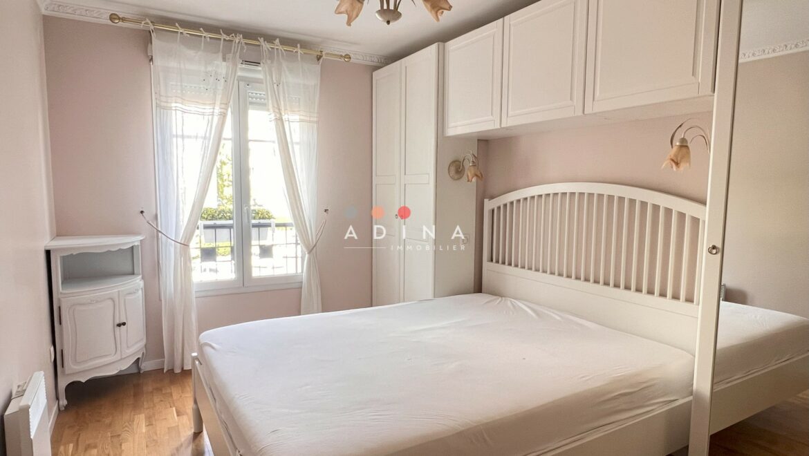 Chambre lumineuse avec lit double et armoire intégrée.