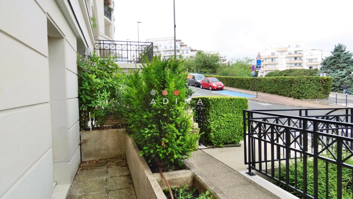 Cour extérieure avec plantes et trottoir au Plessis-Robinson.