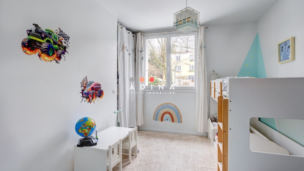 Chambre d'enfant avec lit superposé et décorations murales.