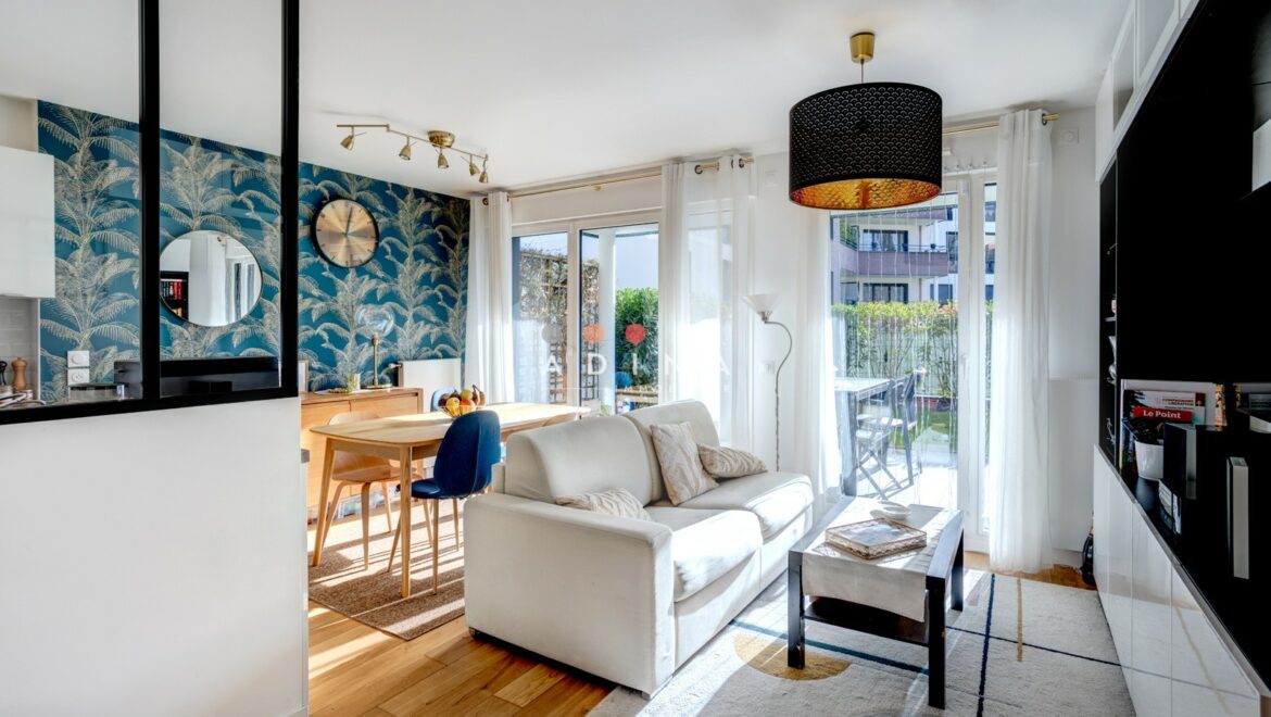 Appartement lumineux avec salon moderne et vue sur jardin.