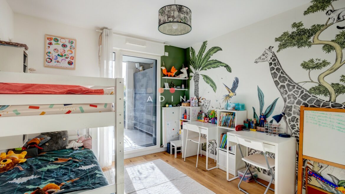 Chambre d'enfant colorée avec lits superposés et bureau.