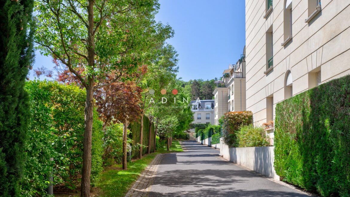 Allée bordée d'arbres et d'immeubles résidentiels.
