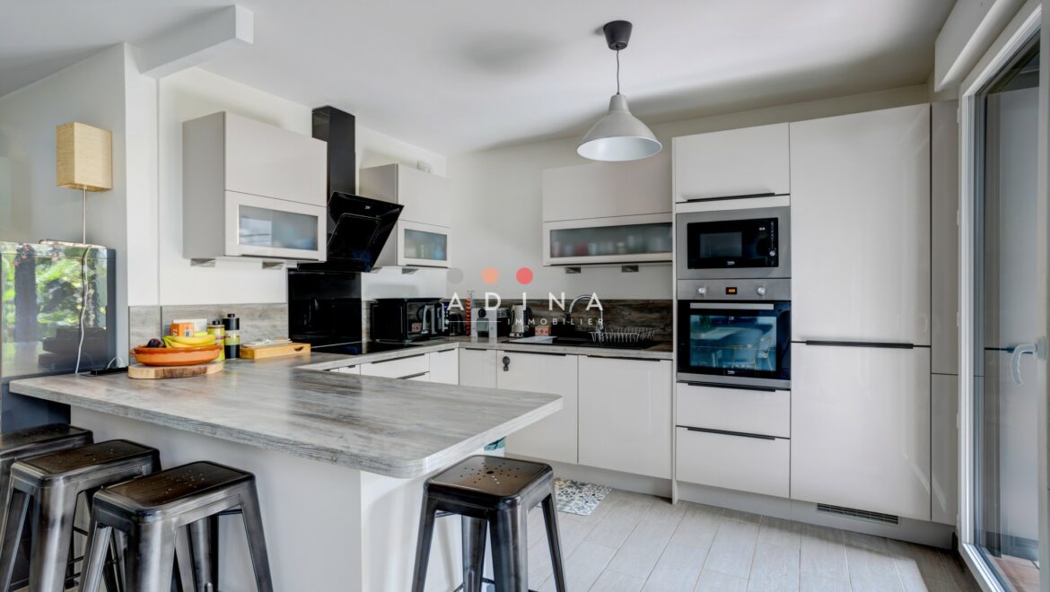 Cuisine moderne avec îlot central et électroménagers intégrés.
