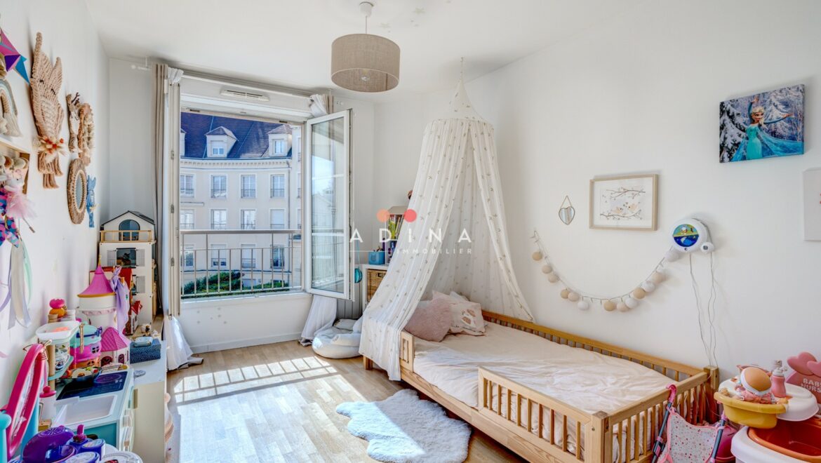 Chambre d'enfant lumineuse avec lit et jouets, fenêtre ouverte.