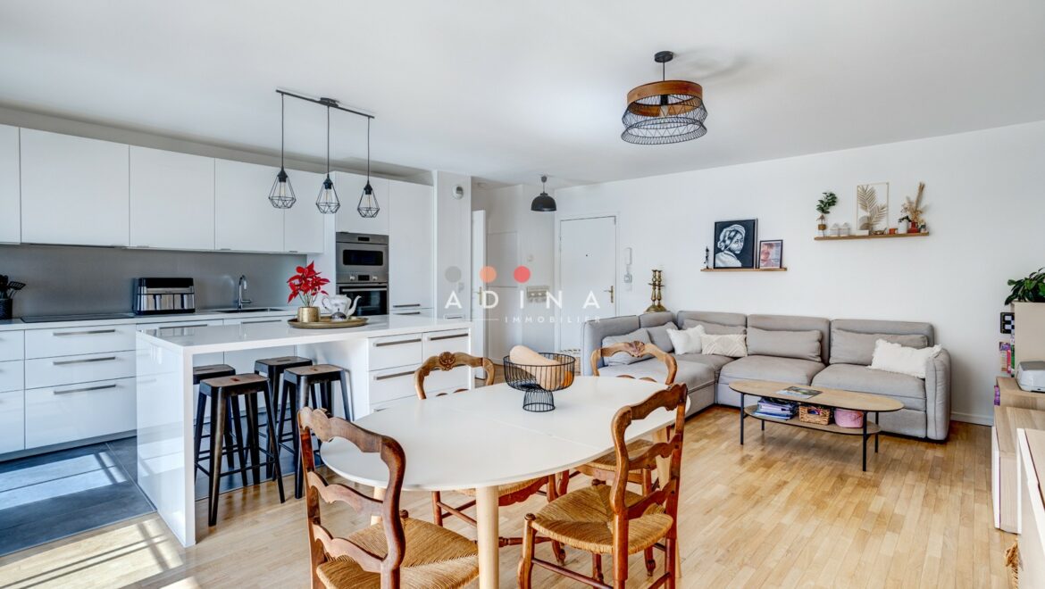 Salon moderne avec cuisine ouverte et mobilier élégant.