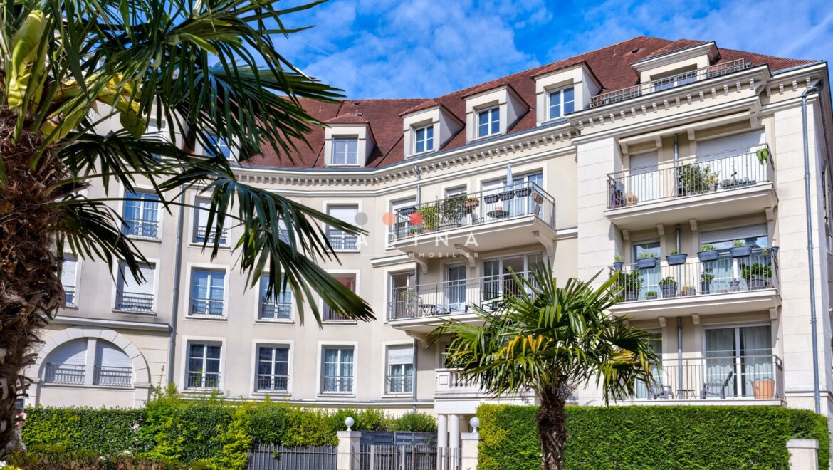 Immeuble résidentiel moderne avec balcons et végétation.