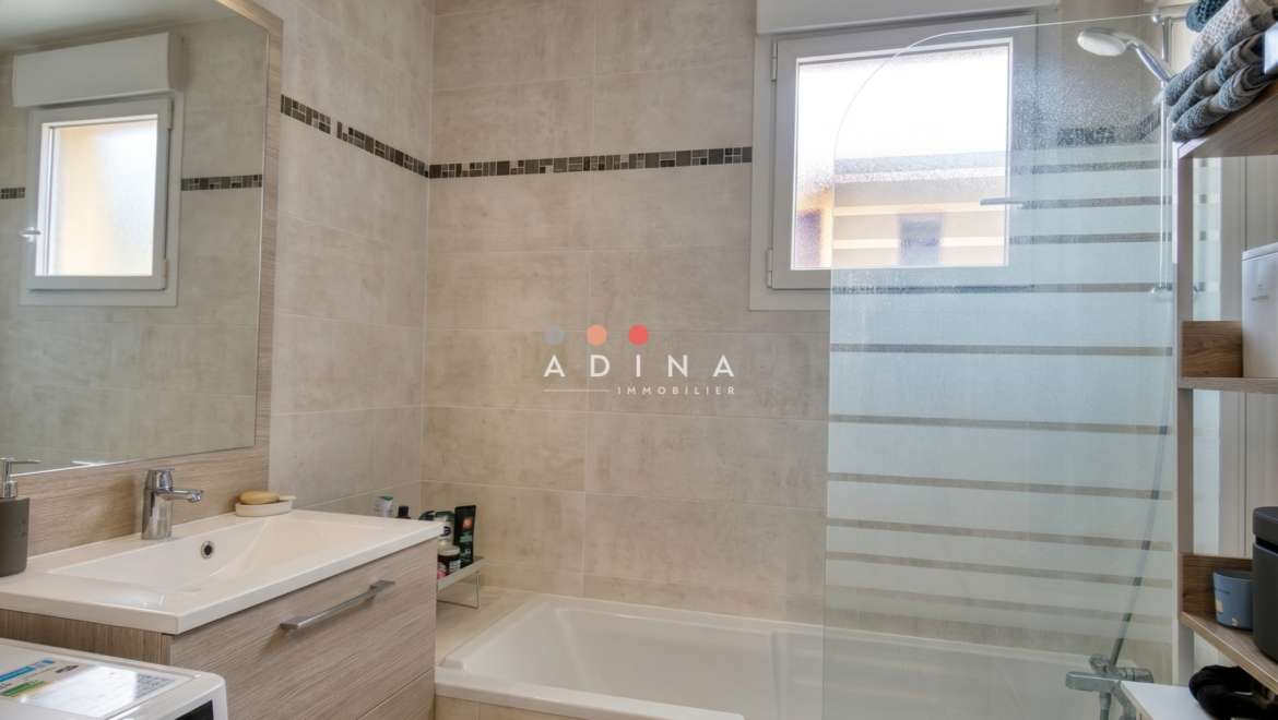 Salle de bain moderne avec baignoire.