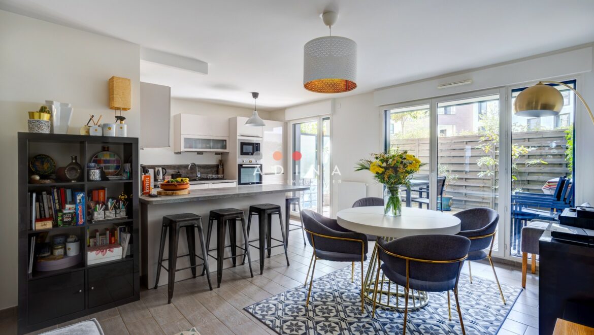 Salle à manger moderne avec cuisine ouverte et grandes fenêtres.