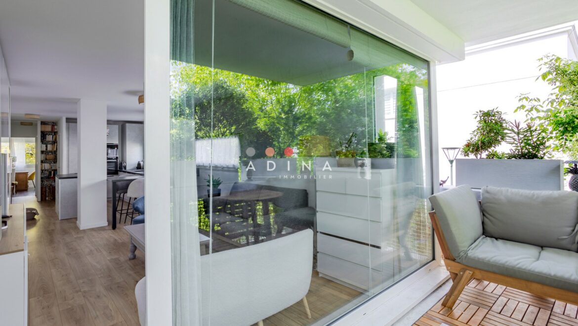 Appartement moderne avec terrasse et grandes baies vitrées.