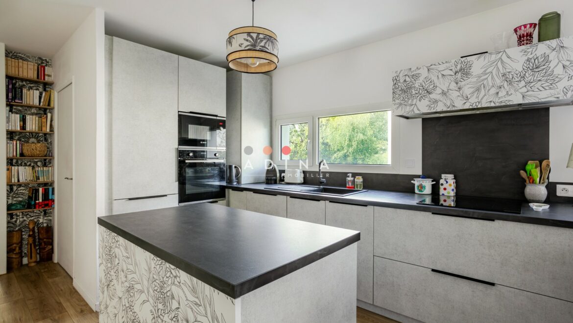 Cuisine moderne avec îlot central et décoration florale à Le Plessis-Robinson.