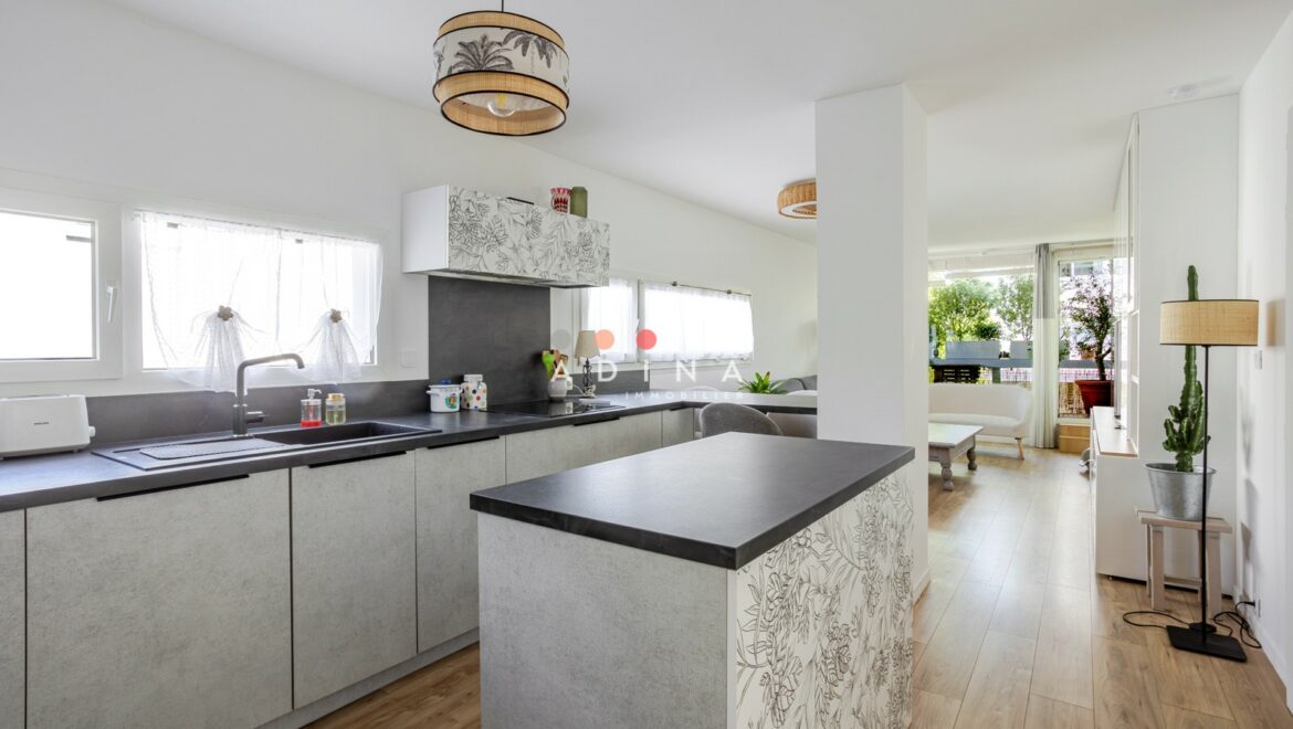 Cuisine moderne avec îlot central et décoration lumineuse.