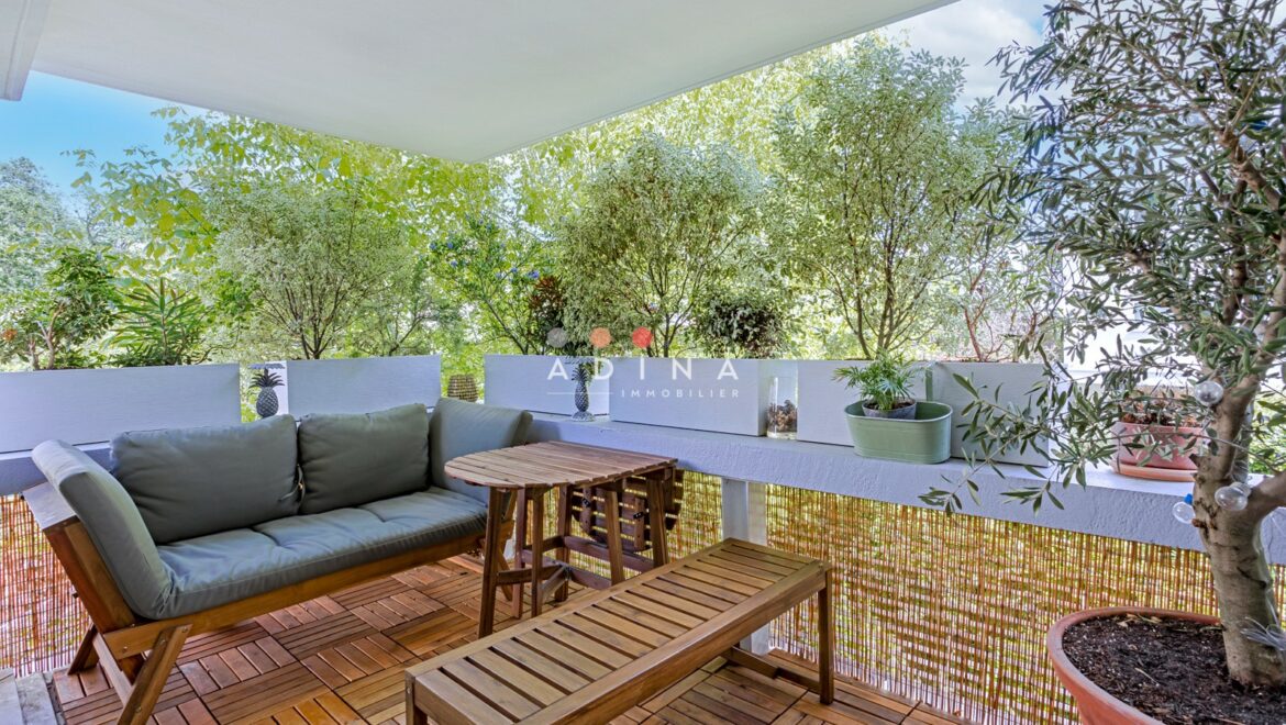 Balcon aménagé avec plantes et mobilier en bois.